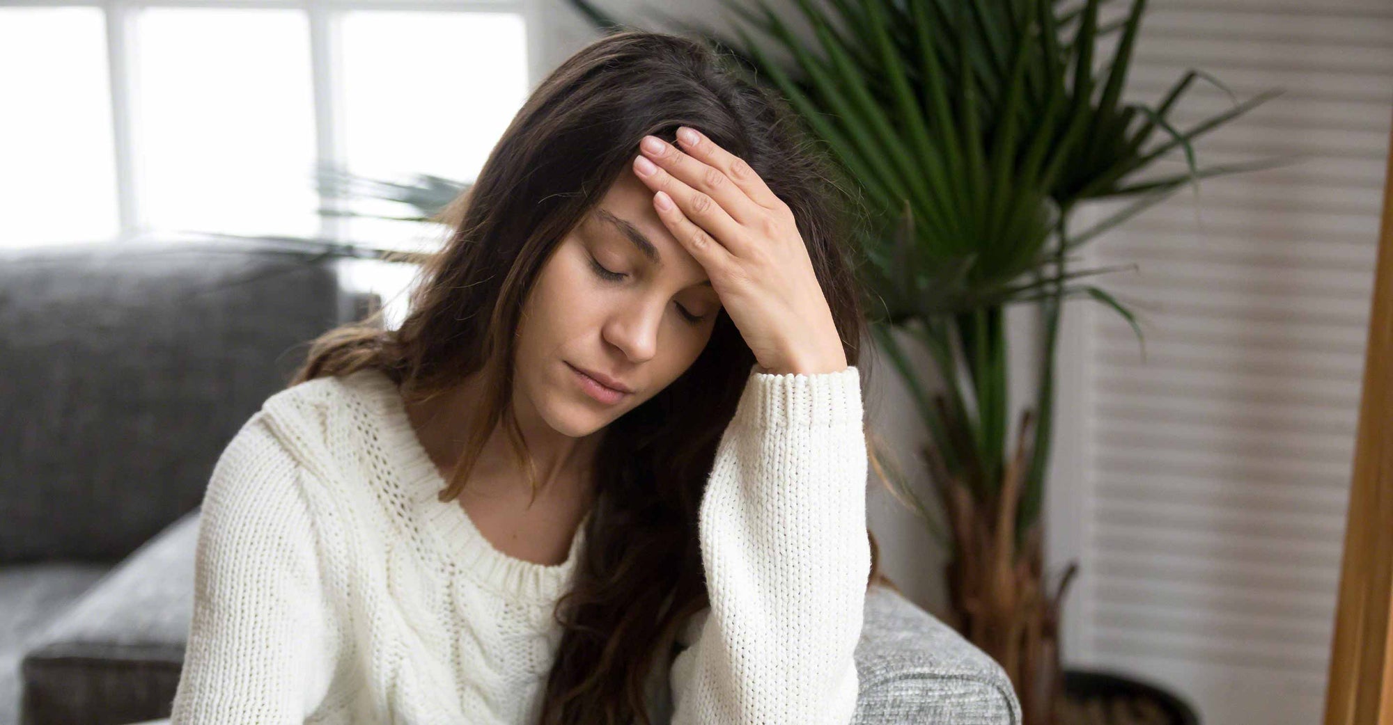 woman holding her head feeling ill